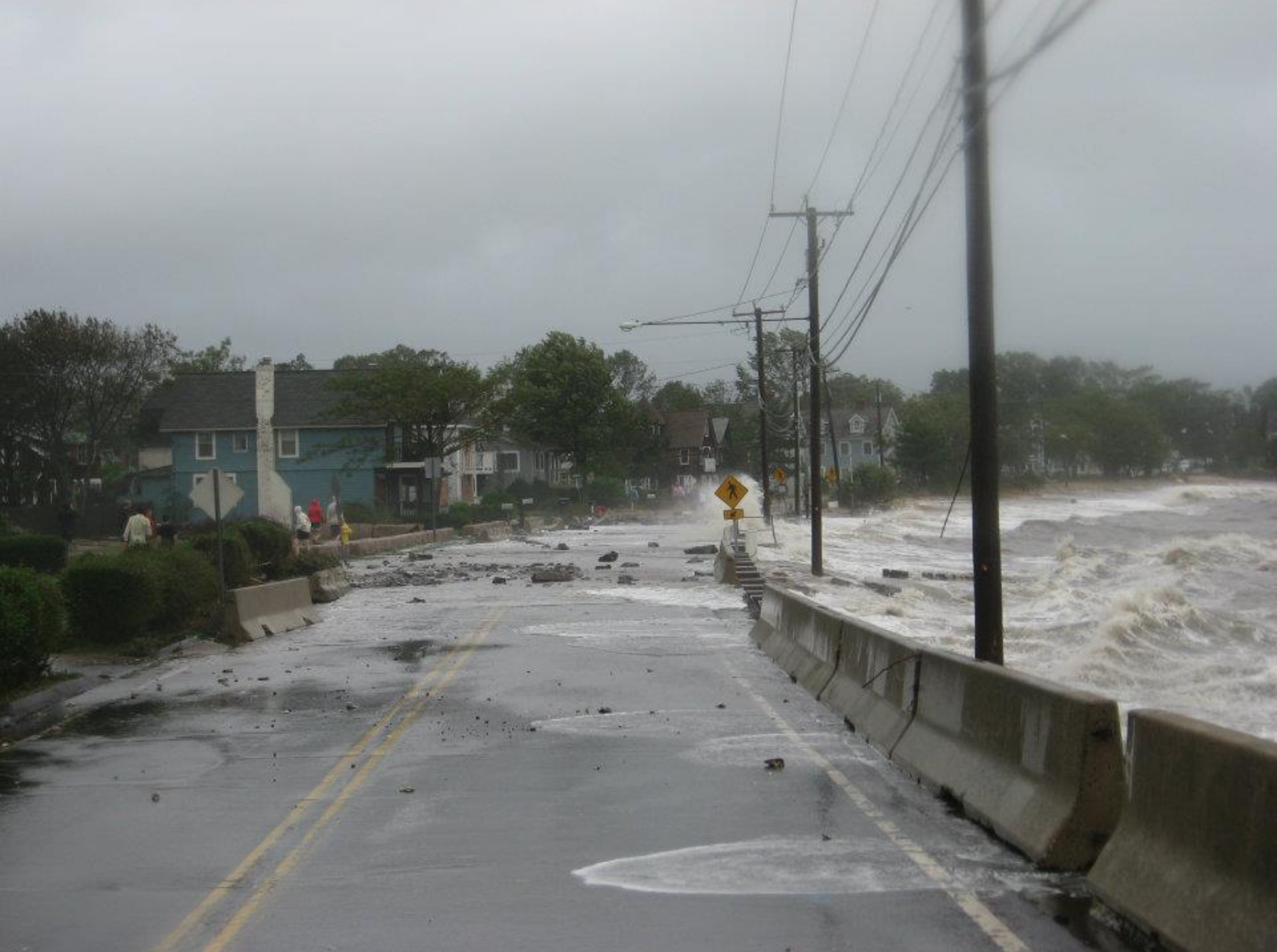 Debris, water, and sand cover the street after the hurricane.